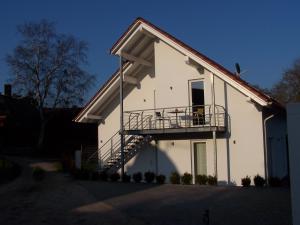 a white house with a balcony on the side of it at Refugium Prerow in Prerow