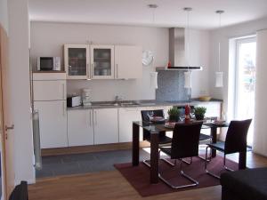 eine Küche und ein Esszimmer mit Tisch und Stühlen in der Unterkunft Refugium Prerow in Prerow
