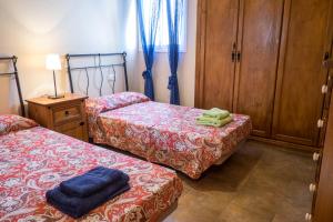 Habitación con 2 camas y armario de madera. en AMAZING DUPLEX 3 bedrooms GOOD WIFI with terrace & BBQ, en Corralejo