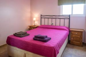コラレホにあるAMAZING DUPLEX 3 bedrooms GOOD WIFI with terrace & BBQのベッドルーム1室(ピンクベッド1台、タオル2枚付)