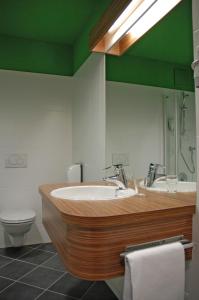 a bathroom with a sink and a toilet and a mirror at Hotel Restaurant Winkler in Mürzzuschlag