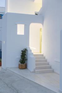 un edificio blanco con escaleras y una maceta en Glykeria, en Agia Anna de Naxos