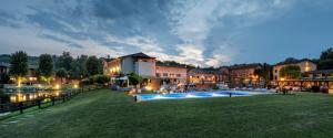 a resort with a swimming pool in front of a building at Hotel Il Corazziere in Merone