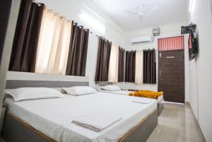 德拉敦Hotel Shiv Kripa的有两张床和一扇窗户的卧室