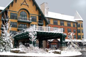 a large brick building with a deck in the snow at The Appalachian at Mountain Creek in Vernon