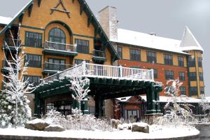 un gran edificio de ladrillo con terraza en la nieve en The Appalachian at Mountain Creek en Vernon