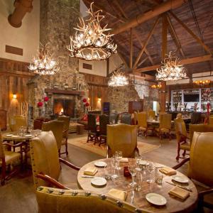 uma sala de jantar com mesas, cadeiras e lustres em The Appalachian at Mountain Creek em Vernon