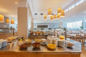 a buffet line with bowls of food in a restaurant at Hotel Zorna Plava Laguna in Poreč