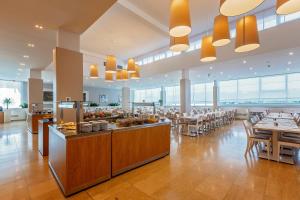 a restaurant with tables and chairs and a buffet at Hotel Zorna Plava Laguna in Poreč