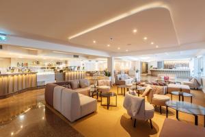 a hotel lobby with couches and tables and a kitchen at Hotel Zorna Plava Laguna in Poreč