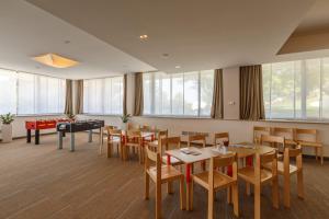a restaurant with tables and chairs and a pool table at Hotel Zorna Plava Laguna in Poreč