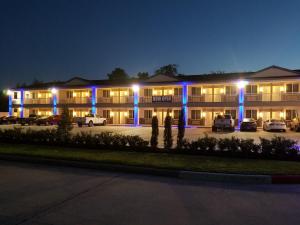 a building with blue lights in a parking lot at Palace Inn Blue Tomball Parkway in Houston