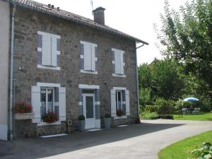 uma casa de tijolos com persianas brancas em L'Ecureuil em Gérardmer