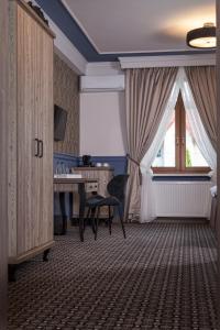 een kamer met een bureau, een stoel en een raam bij Apartamenty Willa w Dolinie in Tarnów