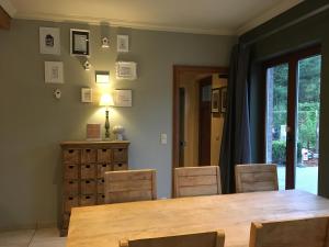 a dining room with a wooden table and chairs at Stropershuisje in Stekene