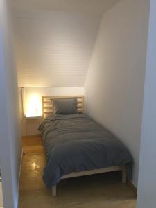 ein Schlafzimmer mit einem Bett in einem weißen Zimmer in der Unterkunft Stropershuisje in Stekene