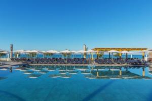 a large swimming pool with chairs and umbrellas at Aparthotel Fontanellas Playa in Playa de Palma