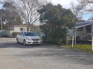 a white car parked in a driveway next to a camper at BIG4 Hay in Hay