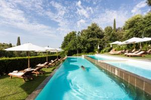 a swimming pool with chairs and umbrellas at Il Salviatino Firenze in Florence