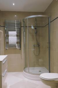 uma casa de banho com uma cabina de duche em vidro e um WC. em Zajazd Restauracja Paradise em Czaplinek