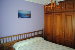 1 dormitorio con 1 cama y armarios de madera en Choyo 2, en Ferrol
