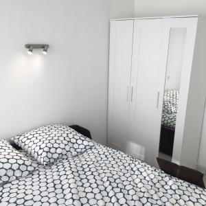 um quarto branco com uma cama e um espelho em Studio carré d'or situé à 50 m de la plage em Nice
