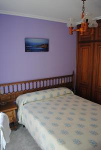 1 dormitorio con cama y pared púrpura en Choyo 2, en Ferrol