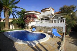 ミアミ・プラトーヤにあるARENDA Villa Coral Pino Altoのスイミングプールと青い椅子2脚付きの家