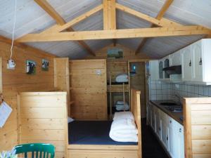 a cabin with a bed in the middle of a kitchen at Chalet - Camping 't Dekske in Wintelre +98 photos