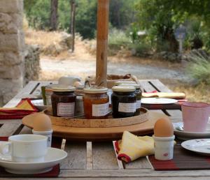 a wooden table with jars of jam and eggs on it at Mas de la Gonnette in Venasque