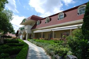 a house with a walkway in front of a building at Hotel Kiss in Tata