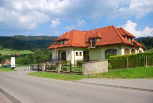 een huis met een oranje dak aan de kant van een weg bij U Kuby in Korbielów