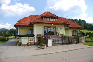 een klein geel huis met een rood dak bij U Kuby in Korbielów