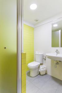 a bathroom with a toilet and a sink at Albergue Inturjoven Sevilla in Seville