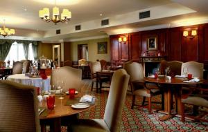 a dining room with tables and chairs in a restaurant at Macdonald Crutherland House in East Kilbride