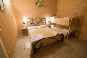 a room with two beds and two bunk beds at Tenuta Masseria del Gallo in Calimera