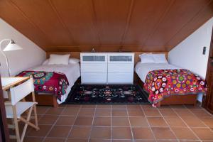 グラナダにあるAlhambra Views Penthouseのベッド2台とデスクが備わる客室です。