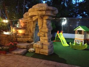 a playground with a rock arch and a slide at HOTEL FELIX Eforie Nord in Eforie Nord