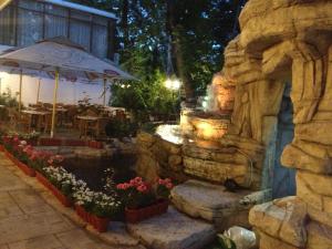 a garden with a fountain and a stone wall at HOTEL FELIX Eforie Nord in Eforie Nord