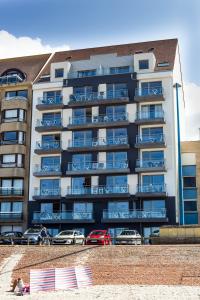 a large apartment building with cars parked in front of it at Evancy Etoile de Mer in Bray-Dunes