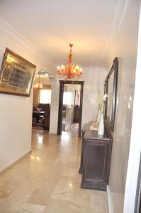 a living room with a chandelier and a hallway at Bri Apartment in Casablanca