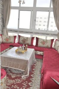 a living room with a red couch with a table at Bri Apartment in Casablanca