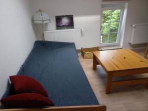 a living room with a blue couch and a table at Hopfenkammer Schorfheide in Golzow