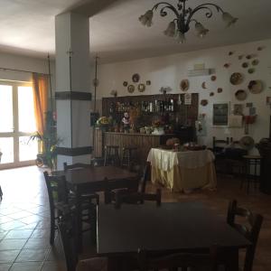 una sala da pranzo con tavoli e sedie e una cucina di Agriturismo le madonnelle a Civitella dʼAgliano
