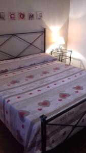 a bedroom with a bed with a floral bedspread at Agriturismo La Carlina in Magliano in Toscana