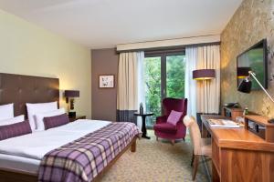 um quarto de hotel com uma cama, uma secretária e uma cadeira em Aspria Hamburg Uhlenhorst em Hamburgo
