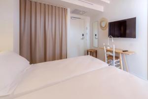a hotel room with a television and a bed at HM Alma Beach in Can Pastilla