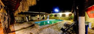 a swimming pool in front of a building at night at Pousada Brésil Aventure in Galinhos