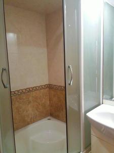 a shower with a glass door in a bathroom at Full Rooms in Kyustendil