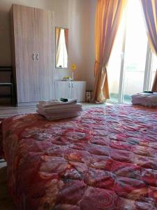 a bedroom with a large bed with a large window at Full Rooms in Kyustendil